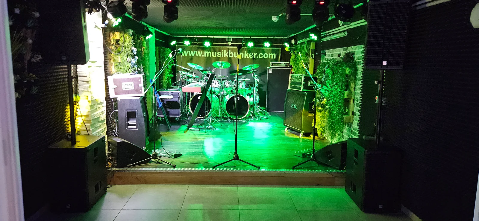 Bühne mit Drumset, Keyboard, Verstärkern und Mikrofonen